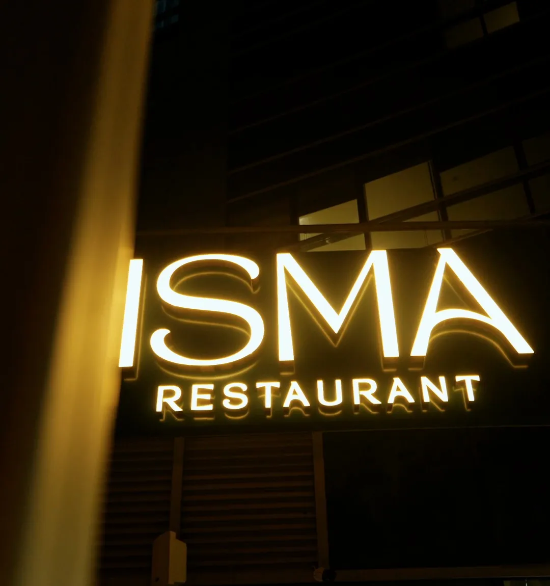 Lit Isma Restaurant sign at night