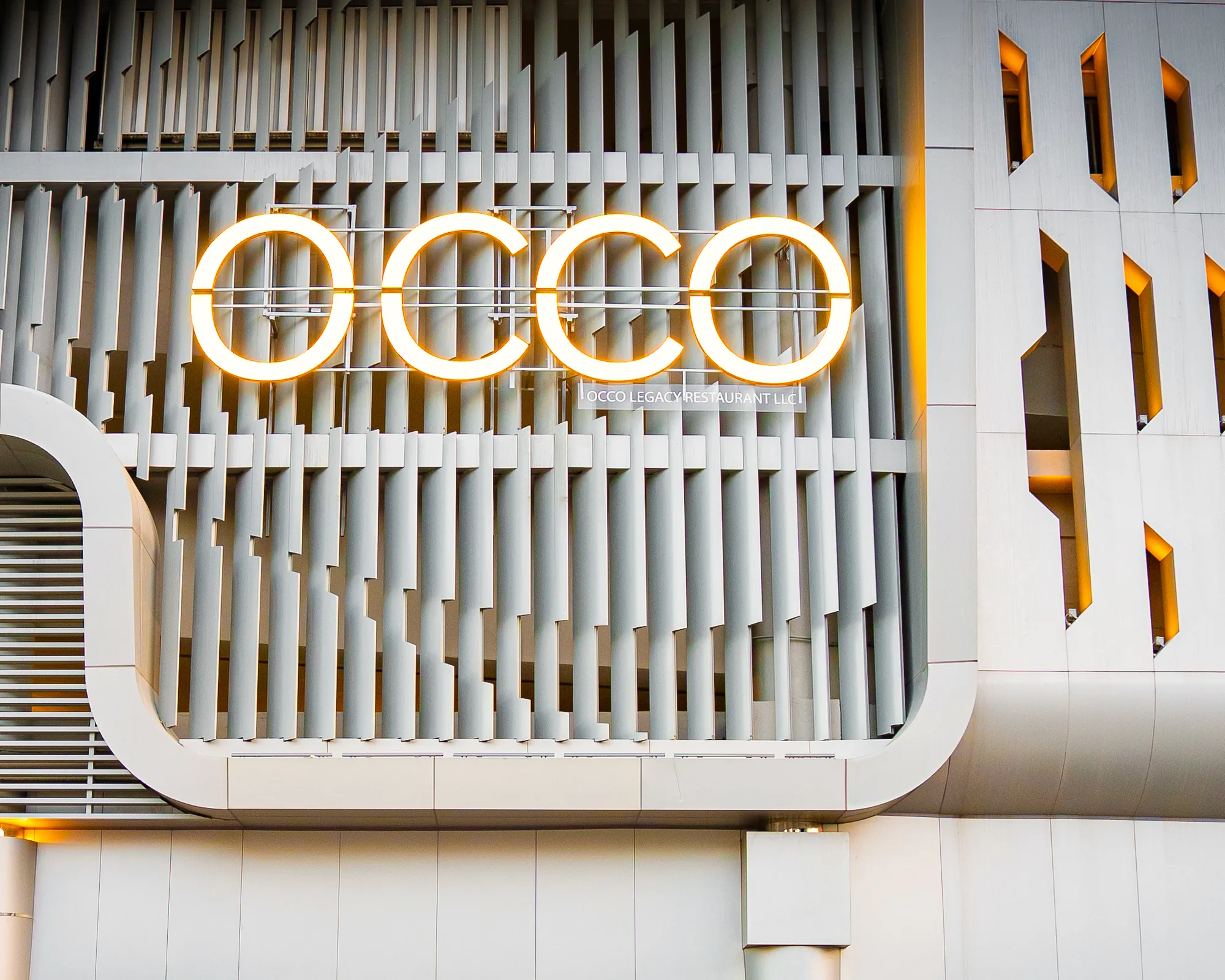 Lit OCCO sign on the Business Bay facade