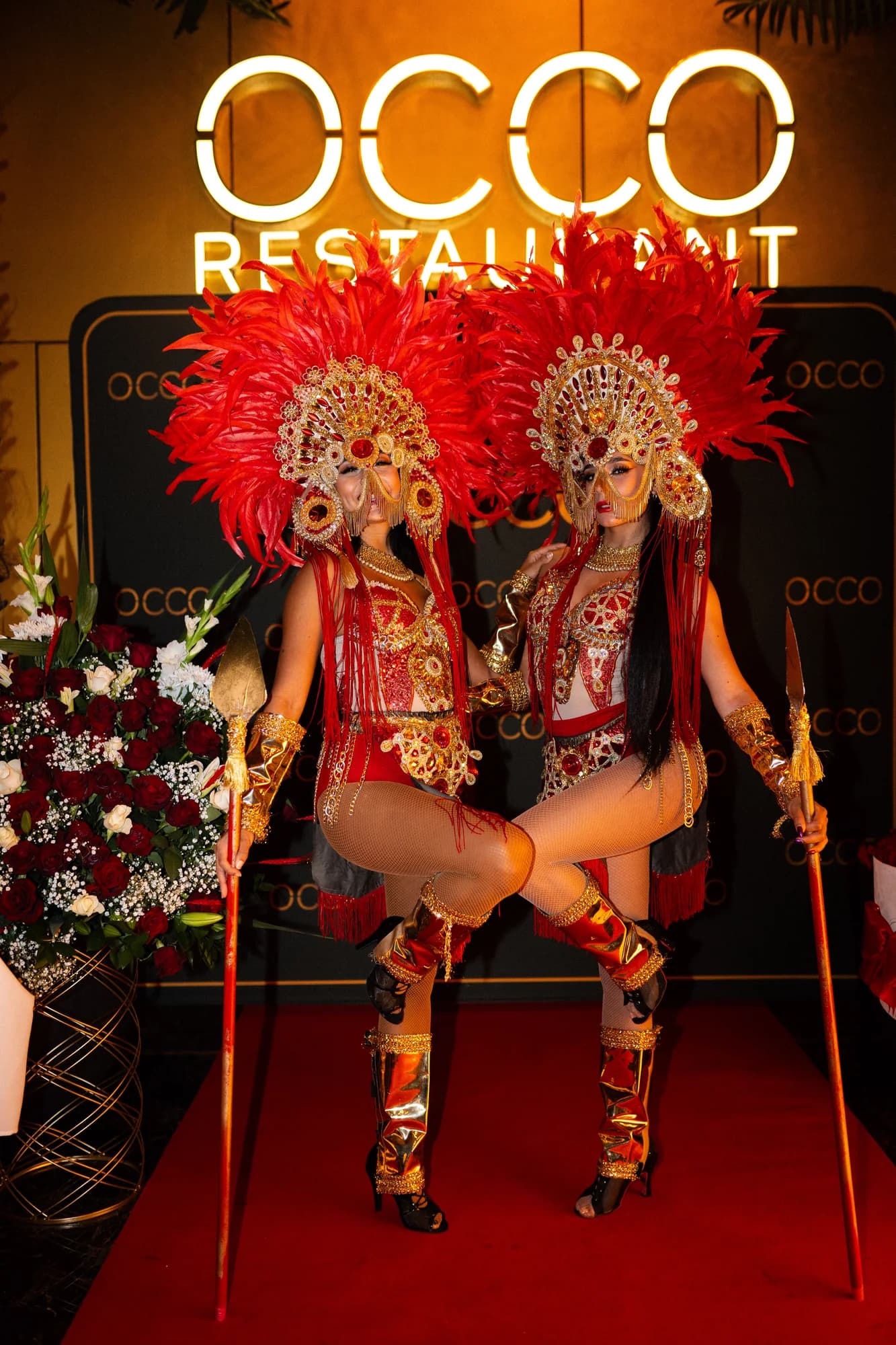 Two carnival dancers under the OCCO sign